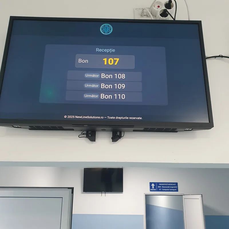 Display-ul recepției montat pe perete, afișând bonul 107 și următoarele bonuri